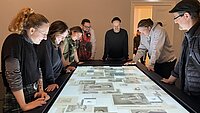 Eine Gruppe Studierender steht um den digitalen Grafiktisch der Kunsthalle Mannheim.