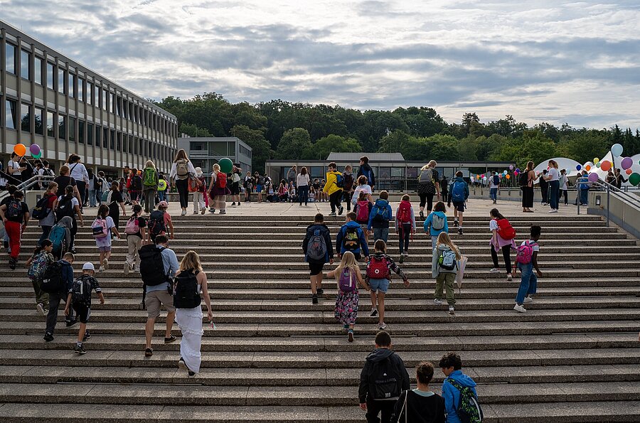 Kinder gehen die Stufen der Außentreppe der PH Ludwigsburg hoch.