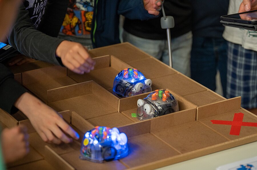 Kinder beim Roboterrenne im ZUge der Kinderuni "Das Roboterrennen! Wer schafft es am schnellsten aus dem Labyrinth? "