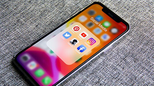 Smartphone, auf dem die Icons für Social Media Apps angezeigt werden